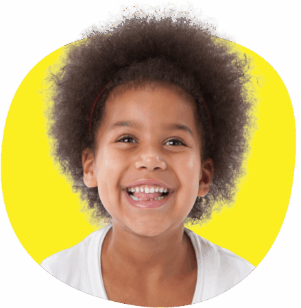 Kiharatukkainen nuori tyttö nauraa iloisesti keltaista taustaa vasten.