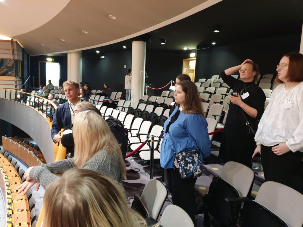 Nuoria parlamenttisalissa tuoleilla tutustumassa tiloihin.